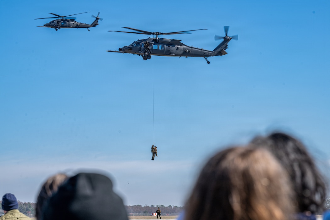 U.S. Air Force Airmen assigned to the 41st Rescue Squadron and the 38th Rescue Squadron simulate hoisting a survivor into an HH-60W Jolly Green II helicopter during an aerial demonstration at Saluting Our Aviation Roots (SOAR) at Moody Air Force Base, Georgia, Feb. 24, 2025. The aerial demonstration allowed members and students to learn more about the 41st RQS and 38th RQS rescue operations. (U.S. Air Force photo by Airman 1st Class Noah Noonan)