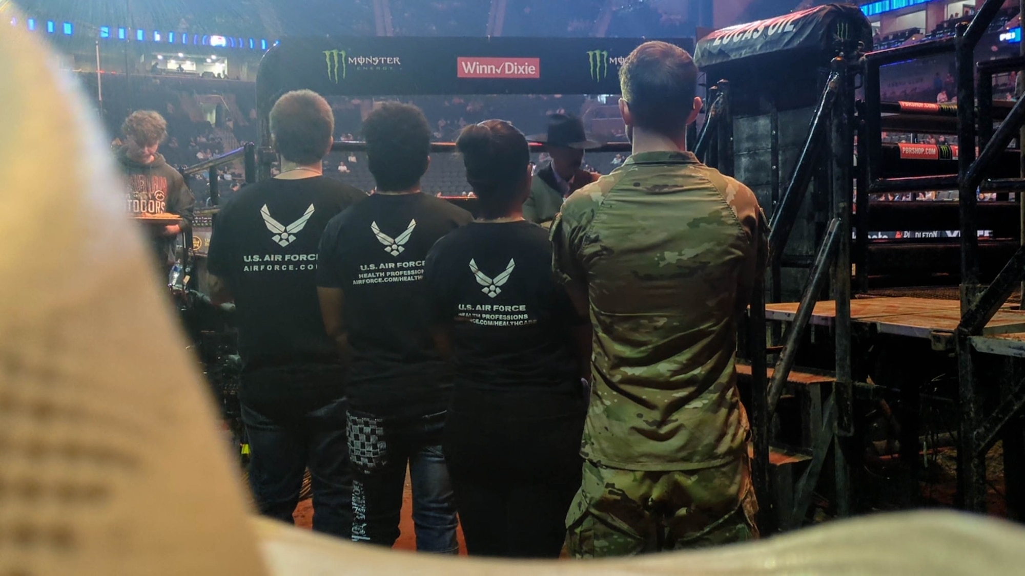 (From left) Joseph Kelly, Nigel Antoine, and Julia Gaiter, Air Force recruits, Delayed Entry Program, Jacksonville, Florida, await entry into the Professional Bull Riders arena before their Oath of Enlistment Ceremony held during the PBR Unleash the Beast tour, Feb. 21, 2026, Jacksonville, Fla. (U.S. Air Force photo by Tech. Sgt. Della Creech)