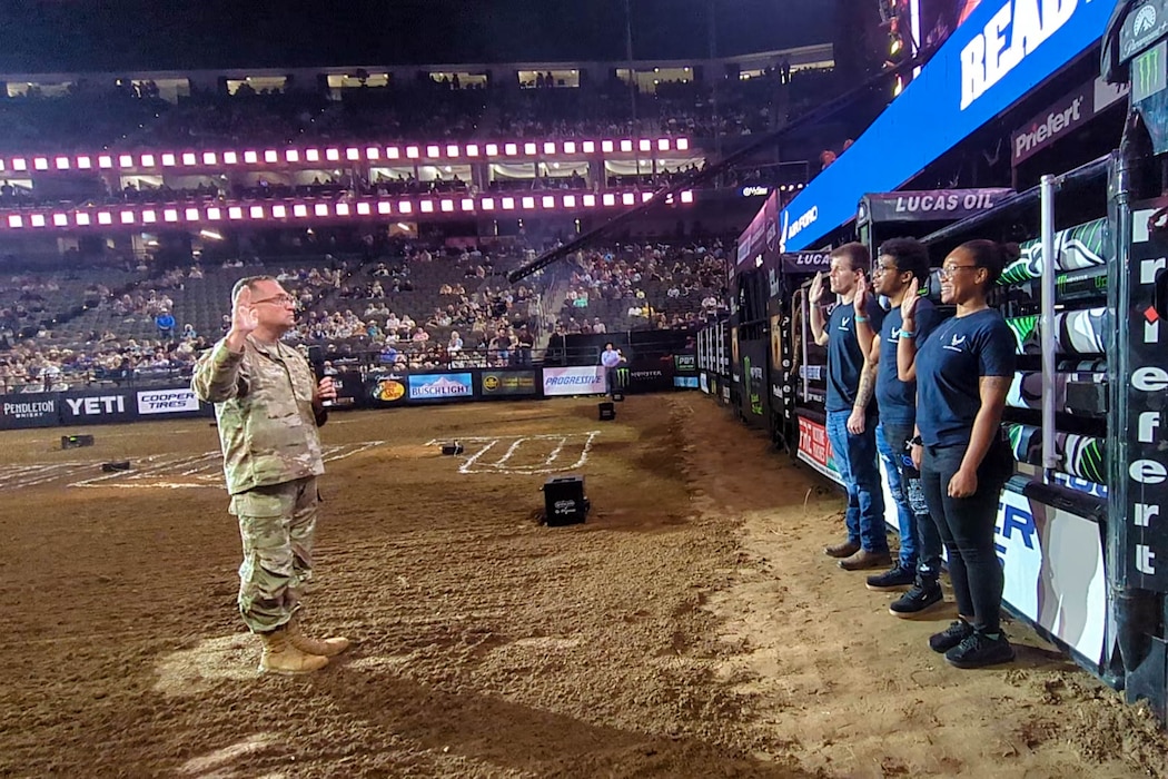 Col. Sean "Metro" Fellows, 367th Recruiting Group commander, Robins Air Force Base, Georgia, delivers the Oath of Enlistment to Joseph Kelly, Nigel Antoine, and Julia Gaiter, Air Force recruits, Delayed Entry Program, Jacksonville, Florida, during the Professional Bull Riders’ Unleash the Beast tour, Feb. 21, 2026, Jacksonville, Fla. (U.S. Air Force photo by Tech. Sgt. Della Creech)