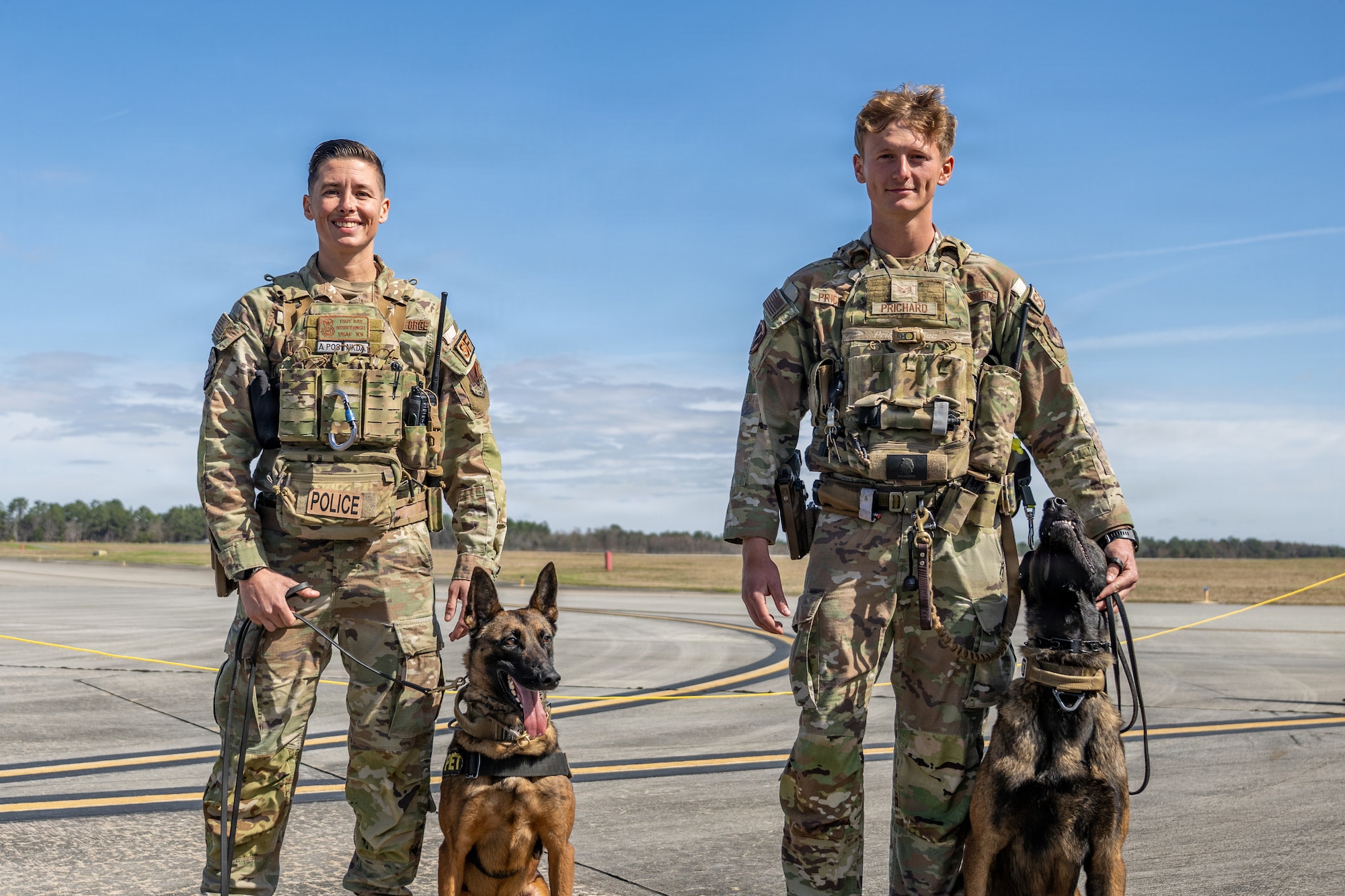 U.S. Air Force Airmen assigned to the 23d Wing pose with their military working dogs during Saluting Our Aviation Roots (SOAR) at Moody Air Force Base, Georgia, Feb. 25, 2026. The Airmen showcased the capabilities and training of their K-9 partners during the event. (U.S. Air Force photo by Senior Airman Savannah Carpenter)
