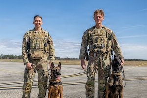 U.S. Air Force Airmen assigned to the 23d Wing pose with their military working dogs during Saluting Our Aviation Roots (SOAR) at Moody Air Force Base, Georgia, Feb. 25, 2026. The Airmen showcased the capabilities and training of their K-9 partners during the event. (U.S. Air Force photo by Senior Airman Savannah Carpenter)