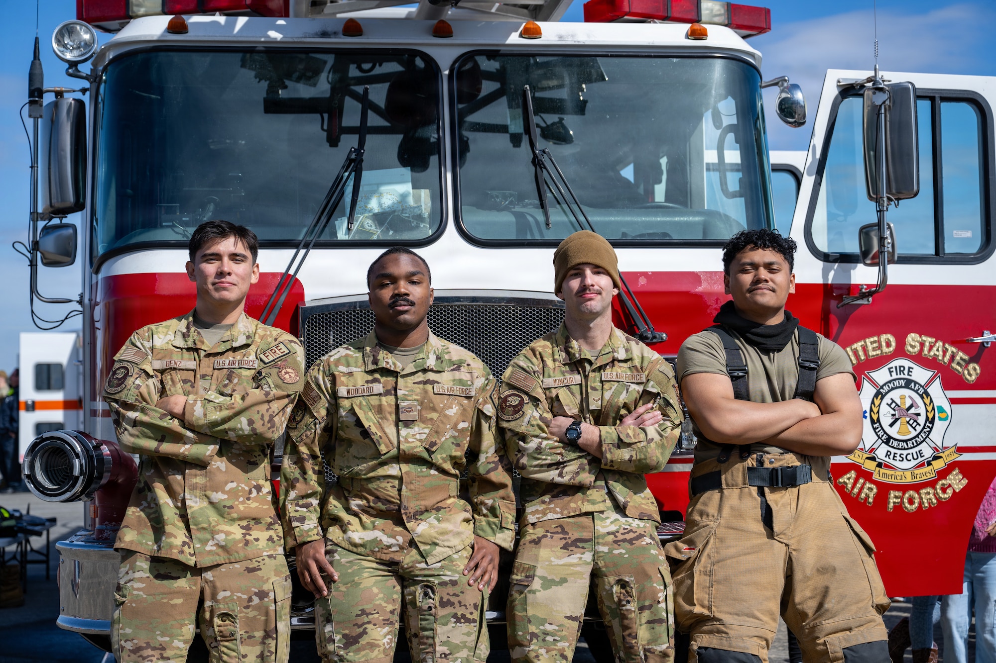 U.S. Air Force Airmen, 23d Civil Engineer Squadron firefighters, pose for a portrait during the Saluting Our Aviation Roots static display at Moody Air Force Base, Georgia, Feb. 24, 2026. The firefighters display specialized equipment, allowing attendees to hold the gear and experience its weight. (U.S. Air Force photo by Airman 1st Class Noah Noonan)