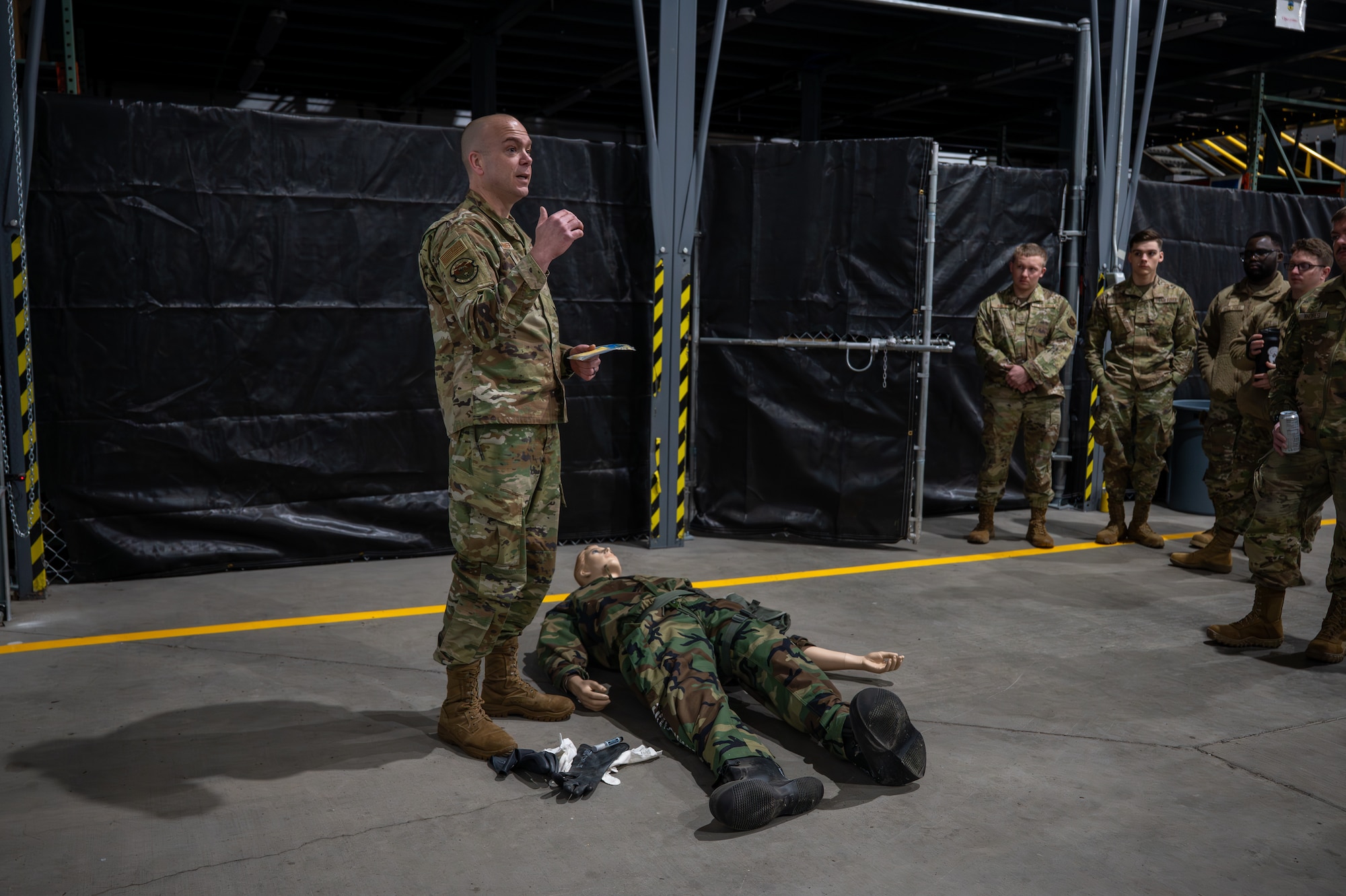 Uniformed man teaches uniformed personnel.