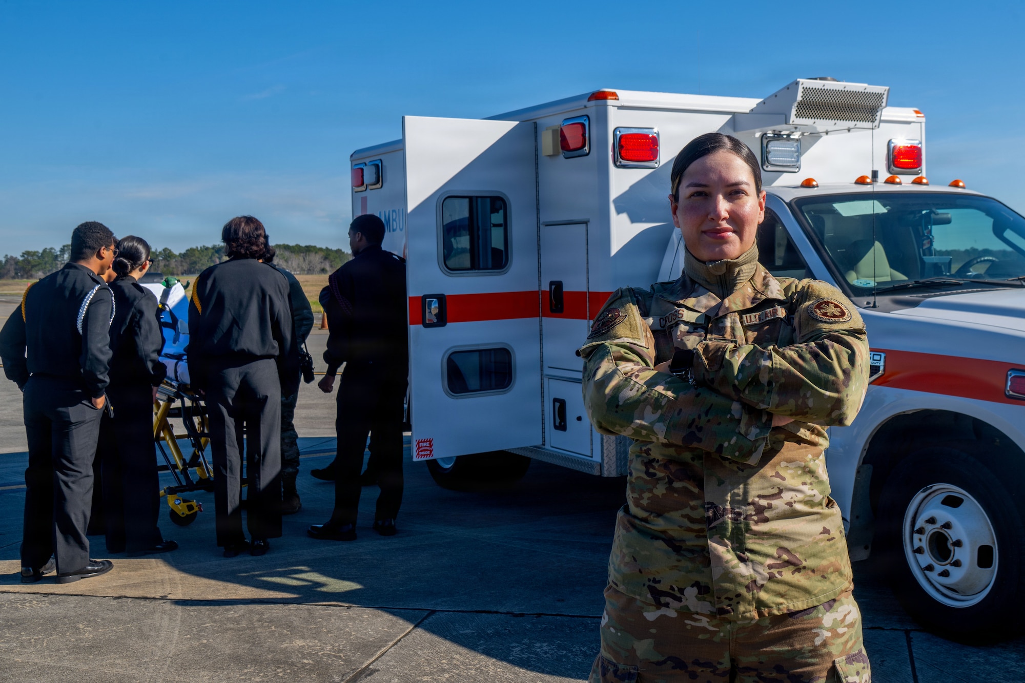 U.S. Air Force Airmen assigned to the 23d Wing pose for a portrait during the Saluting Our Aviation Roots static display at Moody Air Force Base, Georgia, Feb. 25, 2026. Attendees tour an ambulance and learn about its features and capabilities. (U.S. Air Force photo by Airman 1st Class Noah Noonan)