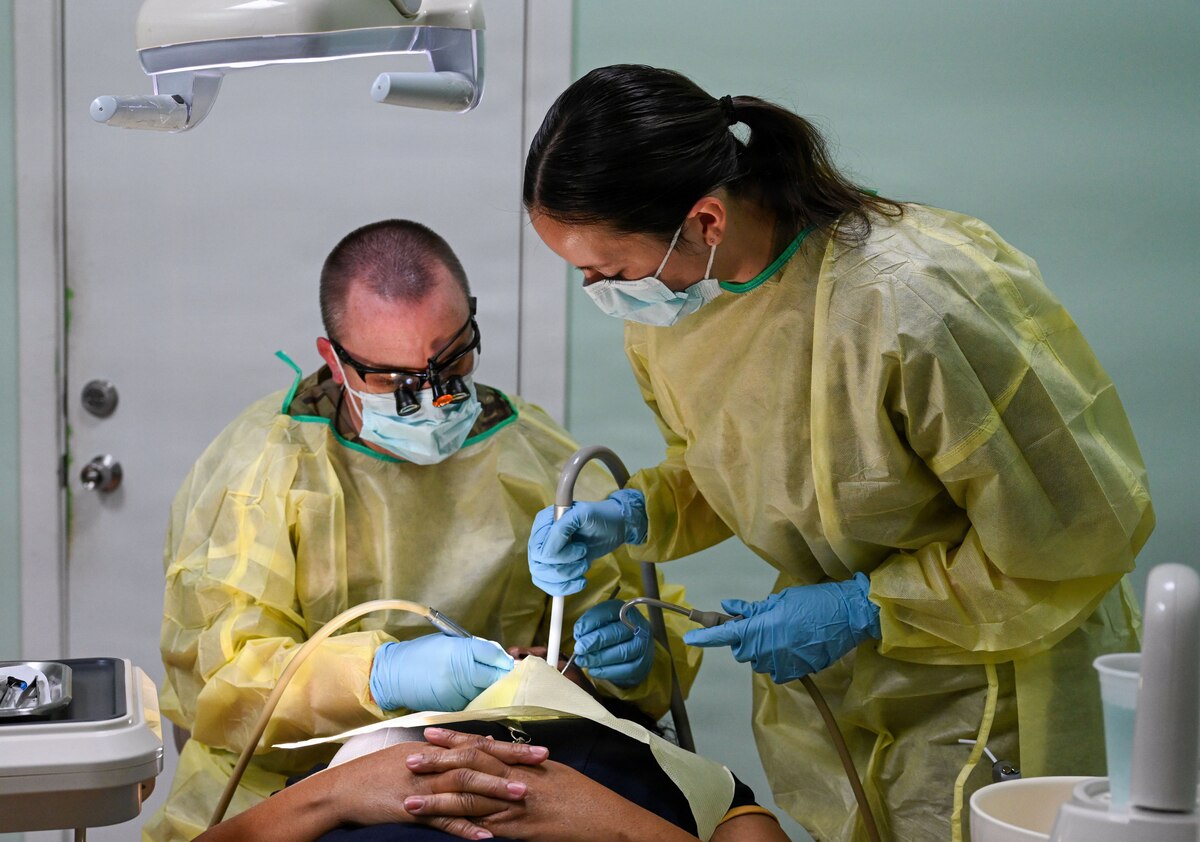 U.S. Air Force Reserve Maj. Andrew Hutchison, 419th Medical Squadron officer-in-charge of the Nevis dental team, left, and U.S. Air Force Tech. Sgt. Courtney Hubenthal, 419th Medical Squadron dental technician, repair a dental filling on a Nevisian patient at Charlestown Dental Clinic in Charlestown, Nevis, Feb. 24, 2026. This procedure was part of the Lesser Antilles Medical Assistance Team 2026 mission, which connects U.S. Airmen with international partners, expanding deployed medical readiness and strengthening the health infrastructure of host nations. (U.S. Air Force Photo by Staff Sgt. Dakota Carter)