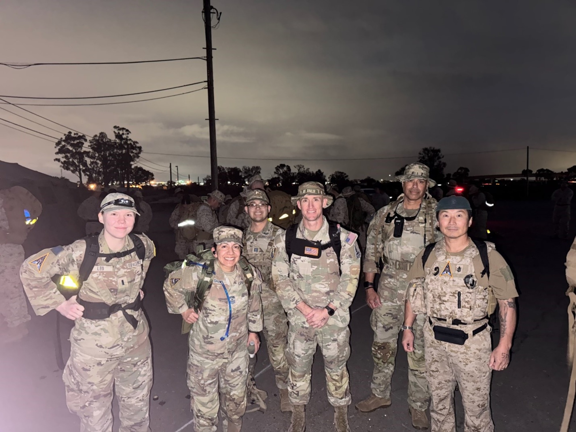 (Left to right) Lt. Jennifer Leo, SYD 88, CMSgt. Jacqueline Sauvé, SSC senior enlisted leader, Capt. Jose Aviles Jr., SYD 84, Lt. Col. Kevin Champaigne, SYD 88, Col. A.J. Ashby SYD 88 commander, and Siggy Pak, USN civilian, gather prior to starting the 30-kilometer Blood Strike Ruck at East Marine Corps Air Station Miramar, Calif., on Feb. 11, 2026. The Norwegian Foot March event was organized by U.S. Marines with Marine Wing Communications Squadron 38, Marine Air Control Group 38, 3rd Marine Aircraft Wing. (USSF Photo by TSgt. Brian Anderson.)
