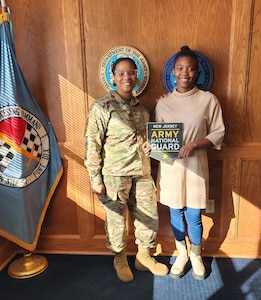 U.S. Army Sgt. 1st Class Malika Moore, a Recruiting and Retention noncommissioned officer with the Recruiting and Retention Battalion, New Jersey Army National Guard, left, and Spc. Sanaa Drinks, right, pose for a photo following an oath of an enlistment at Joint Base McGuire-Dix-Lakehurst, New Jersey.