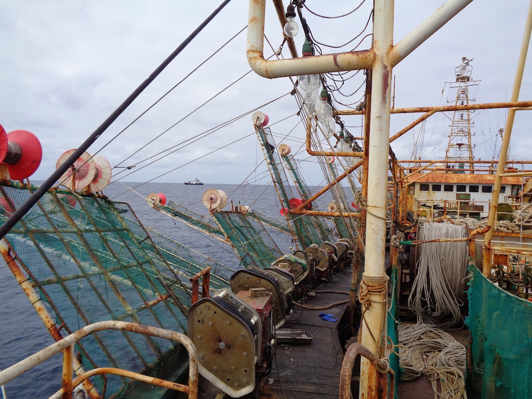 Coastguardsmen’s view looking aft across deck of squid jigger vessel during boarding inspection, with USCGC Alder in background, during Operation Southern Shield 2023, October 2023 (U.S. Coast Guard)