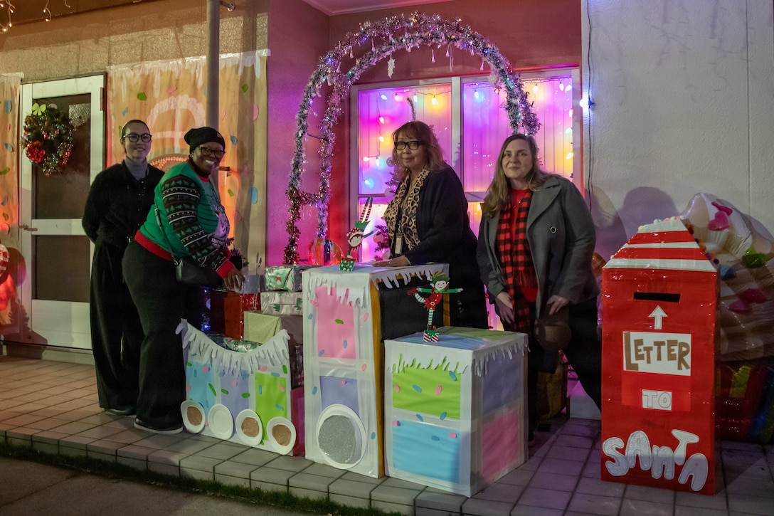 Iwakuni Family Housing Office employees pose for a group photo at a contestant’s home during a Holiday Decoration Contest at Marine Corps Air Station Iwakuni, Japan, Dec. 17, 2025. The Iwakuni Family Housing office hosted the Holiday Decoration Contest to bring the community of MCAS Iwakuni together by showcasing festive lights and holiday decoration. (U.S. Marine Corps photo by Lance Cpl. Donald Dugger)