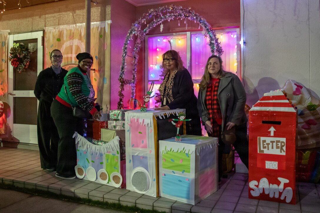 Iwakuni Family Housing Office employees pose for a group photo at a contestant’s home during a Holiday Decoration Contest at Marine Corps Air Station Iwakuni, Japan, Dec. 17, 2025. The Iwakuni Family Housing office hosted the Holiday Decoration Contest to bring the community of MCAS Iwakuni together by showcasing festive lights and holiday decoration. (U.S. Marine Corps photo by Lance Cpl. Donald Dugger)