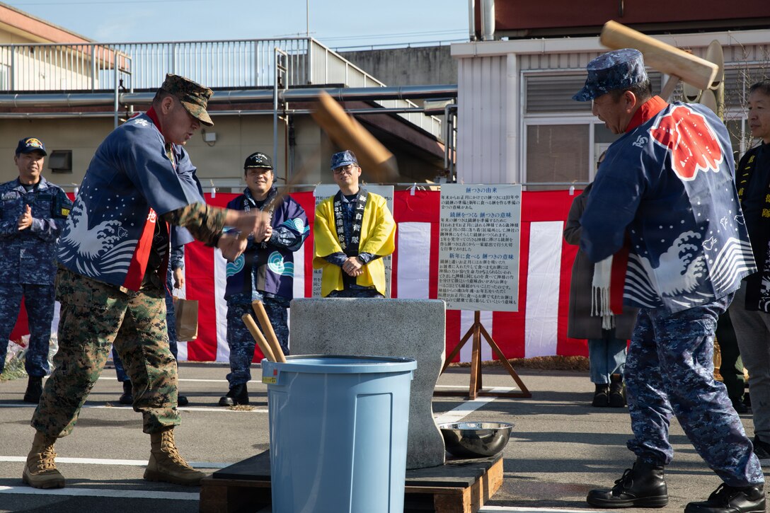 U.S. Marine Corps Sgt. Maj. Richard Johnson, left, the sergeant major of Marine Corps Air Station Iwakuni, and native of Washington D.C., and Japan Maritime Self-Defense Force Chief Petty Officer Kenichiro Chikamori, the command master chief petty officer of Fleet Air Wing 31, hammer rice together during a traditional Mochitsuki event at MCAS Iwakuni, Japan, Dec. 19, 2025. FAW 31 Iwakuni hosted an annual Mochitsuki event with Aircraft Intermediate Maintenance Department (AIMD) for the MCAS Iwakuni community to participate and learn more about Japanese New Year’s traditions and culture. (U.S. Marine Corps photo by Lance Cpl. Siwan Lewis)