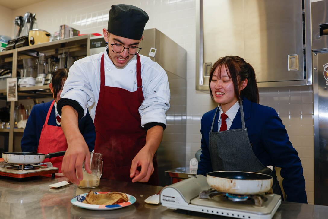 Students from Matthew C. Perry High School and students from Karyō High School prepare crepes during the sister-school agreement at M.C. Perry High School, Marine Corps Air Station Iwakuni, Japan, Dec. 12, 2025. This sister school agreement aims to strengthen cultural and educational ties between Japanese and American students, provide real-world English and Japanese language immersion, and promote a long-term student exchange between Japan and the U.S. military community. (U.S. Marine Corps photo by Lance Cpl. Isaac De Leon)