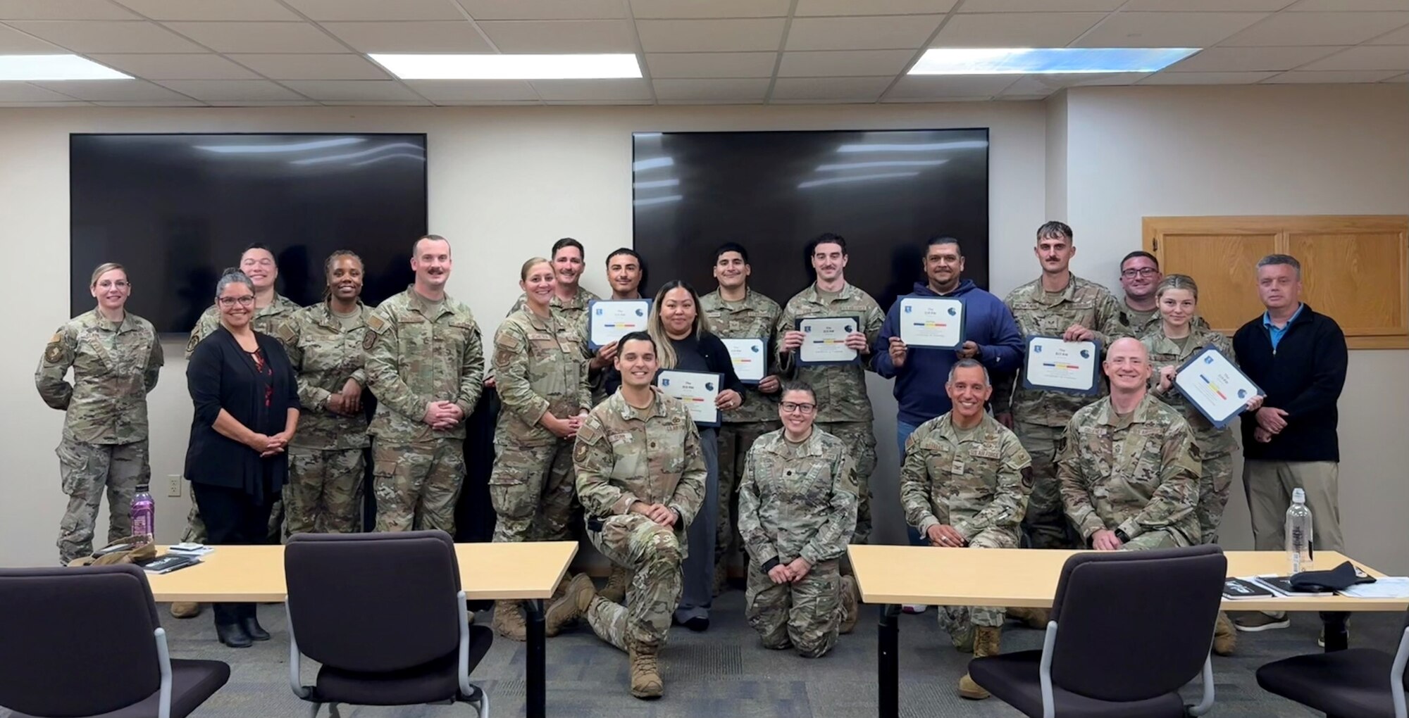A photo of a group of people standing with certificates.