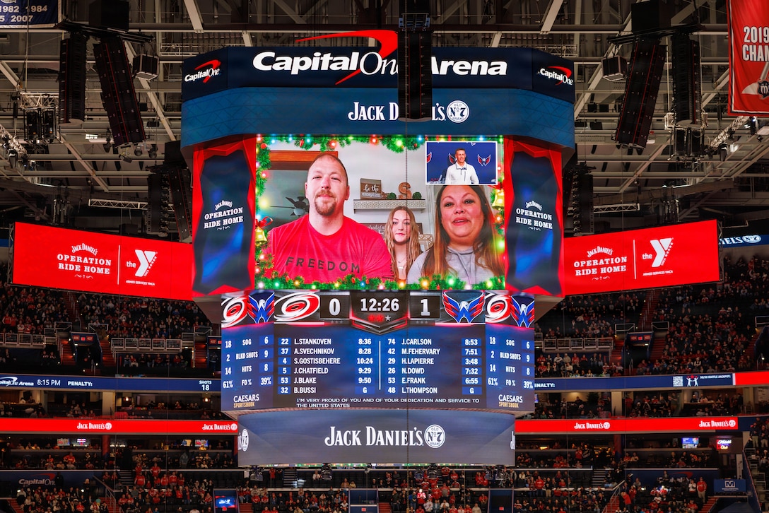 The family of U.S. Marine Corps Lance Cpl. Logan Slater, a military police officer with Security Battalion, wish him a happy holidays during a hockey game between the Washington Capitals and Carolina Hurricanes at Capital One Areana in Washington, D.C., Dec 11, 2025. Slater was gifted a plane ticket home and Washington Capital merchandise from the Armed Services Young Man's Christian Association's Operation Ride Home. Operation Ride Home provides travel assistance to service members and their families, helping them travel home for the holidays. The program, open to active duty and reserve personnel from ranks E-1 to E-5, aims to strengthen military families by bridging gaps that can prevent holiday travel. (U.S. Marine Corps photo by Lance Cpl. Federico Marquez)
