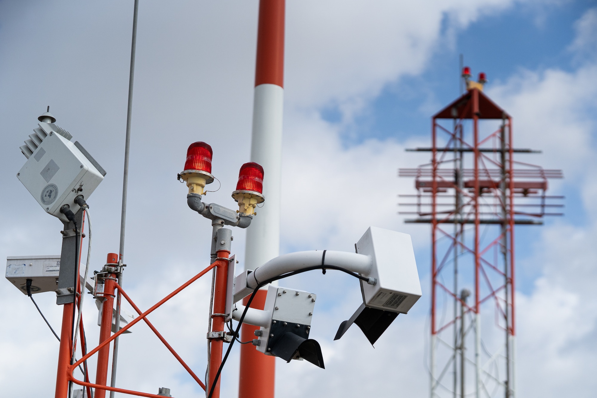 A white and red striped airfield weather sensor.