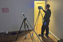 Person standing in empty room programming FARO scanner