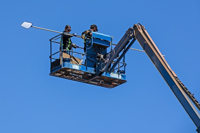 Two people in the bucket of a crane lift