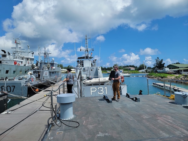 two people standing on the deck of a ship.