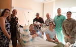 Staff from the Mother Baby Unit at Tripler Army Medical Center, along with Col. William Bimson, commander of TAMC, presented a baby gift basket to U.S. Army Capt. Henry Zenger and Capt. Cecilia Zenger after the birth of their son, Gus Zenger, at TAMC in Honolulu, Hawaii, on Jan. 1, 2026. Gus, born at 5:16 a.m. on New Year’s Day, is TAMC’s first baby boy of 2026. (Defense Health Agency photo by Khinna Kaminske)