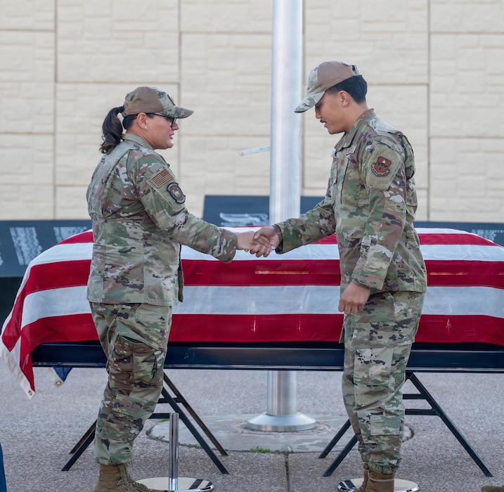 U.S. Air Force Lt. Col. Maria Berardo (left), 56th Force Support Squadron commander, shakes hands with Senior Airman Matthew Lucero (right), 56th Fighter Wing honor guardsman, after presenting a challenge coin for exceptional performance during a ceremony, Dec. 2, 2025, at Luke Air Force Base, Arizona.
