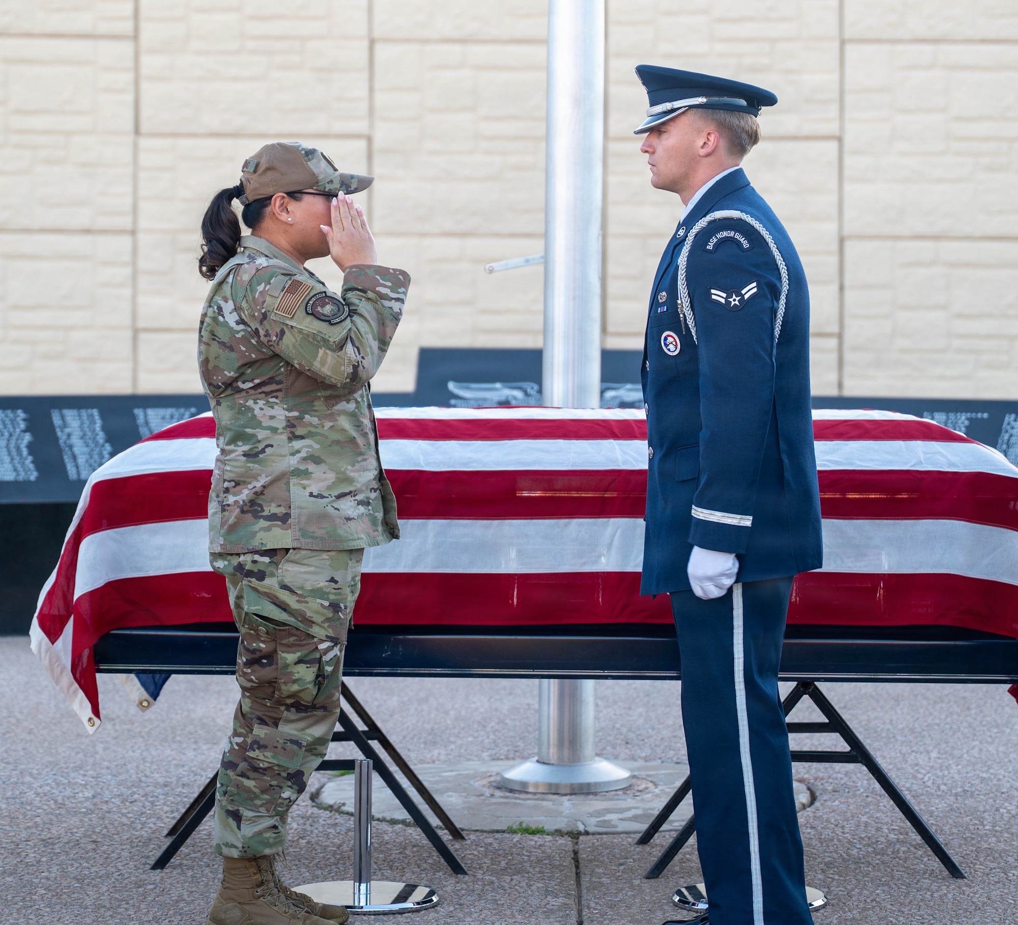 U.S. Air Force Lt. Col. Maria Berardo (left), 56th Force Support Squadron commander, and Airman 1st Class Trevor Smart (right), 56th Fighter Wing honor guardsman, returns a salute after a challenge coin presentation recognizing exceptional service during a ceremony, Dec. 2, 2025, at Luke Air Force Base, Arizona.