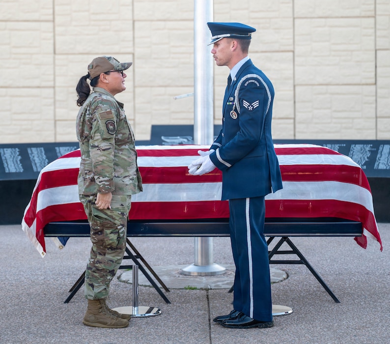 U.S. Air Force Lt. Col. Maria Berardo (left), 56th Force Support Squadron commander, presents a challenge coin from the Vice Chief of Staff of the Air Force to Senior Airman Matthew Mangeson (right), 56th Fighter Wing honor guardsman during a ceremony, Dec. 2, 2025, at Luke Air Force Base, Arizona.