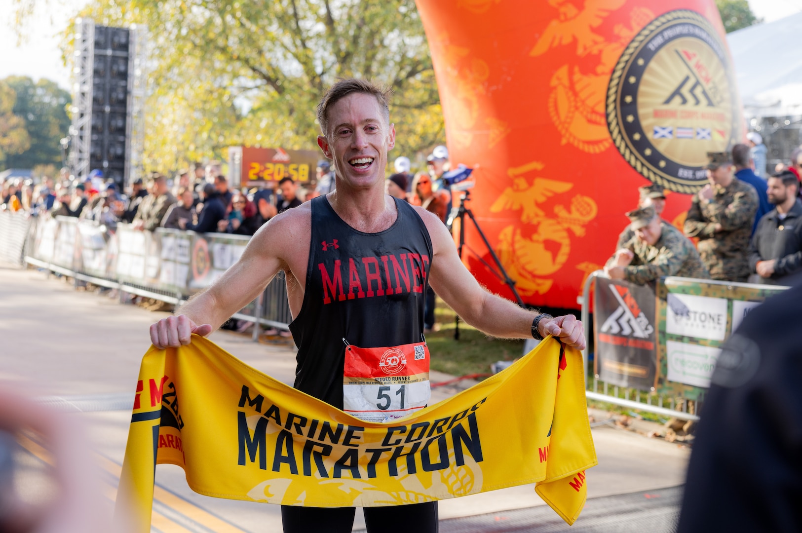 U.S. Marine Corps Maj. Kyle King, the first-place male finisher of the 50th annual Marine Corps Marathon, poses with the Marine Corps Marathon banner in Arlington, Virginia, Oct. 26, 2025. The 2025 “People’s Marathon” featured the hallmark esprit de corps, perseverance, and community spirit the race is known for. Tens of thousands of runners converged on D.C., Maryland, and Virginia to not only show support for the Marine Corps and their country, but also for the unique experience of running this iconic course alongside Marines. (U.S. Marine Corps photo by Sgt. Chancellor Reynolds)