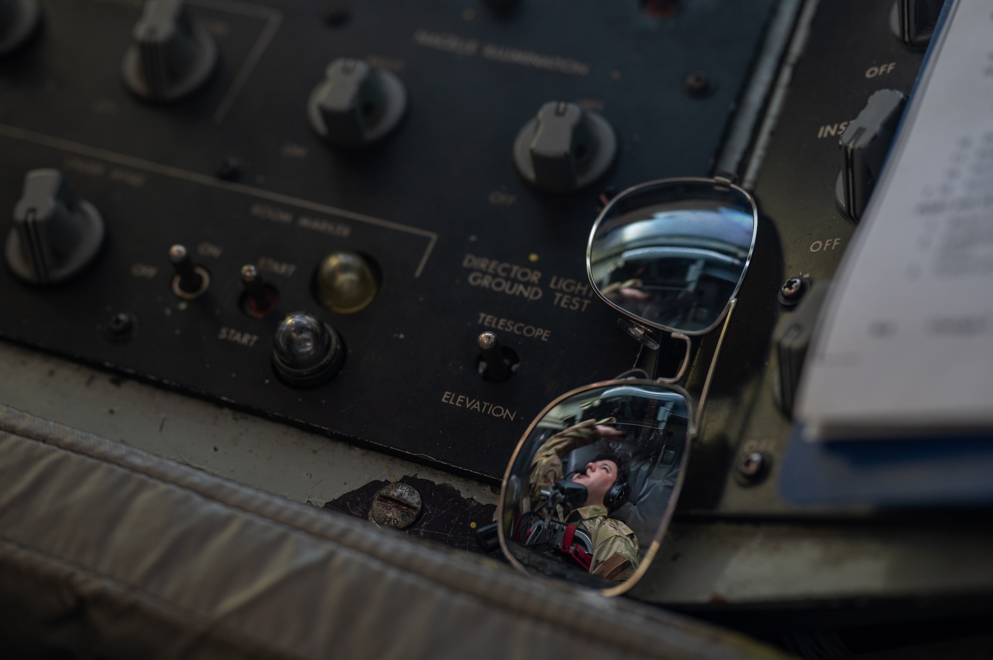 A photo os a pair of sunglasses with a reflection of the boom operator.