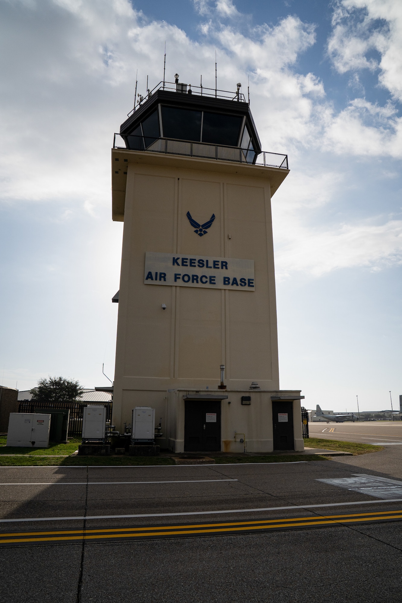 An air traffic control tower in front of the sun.