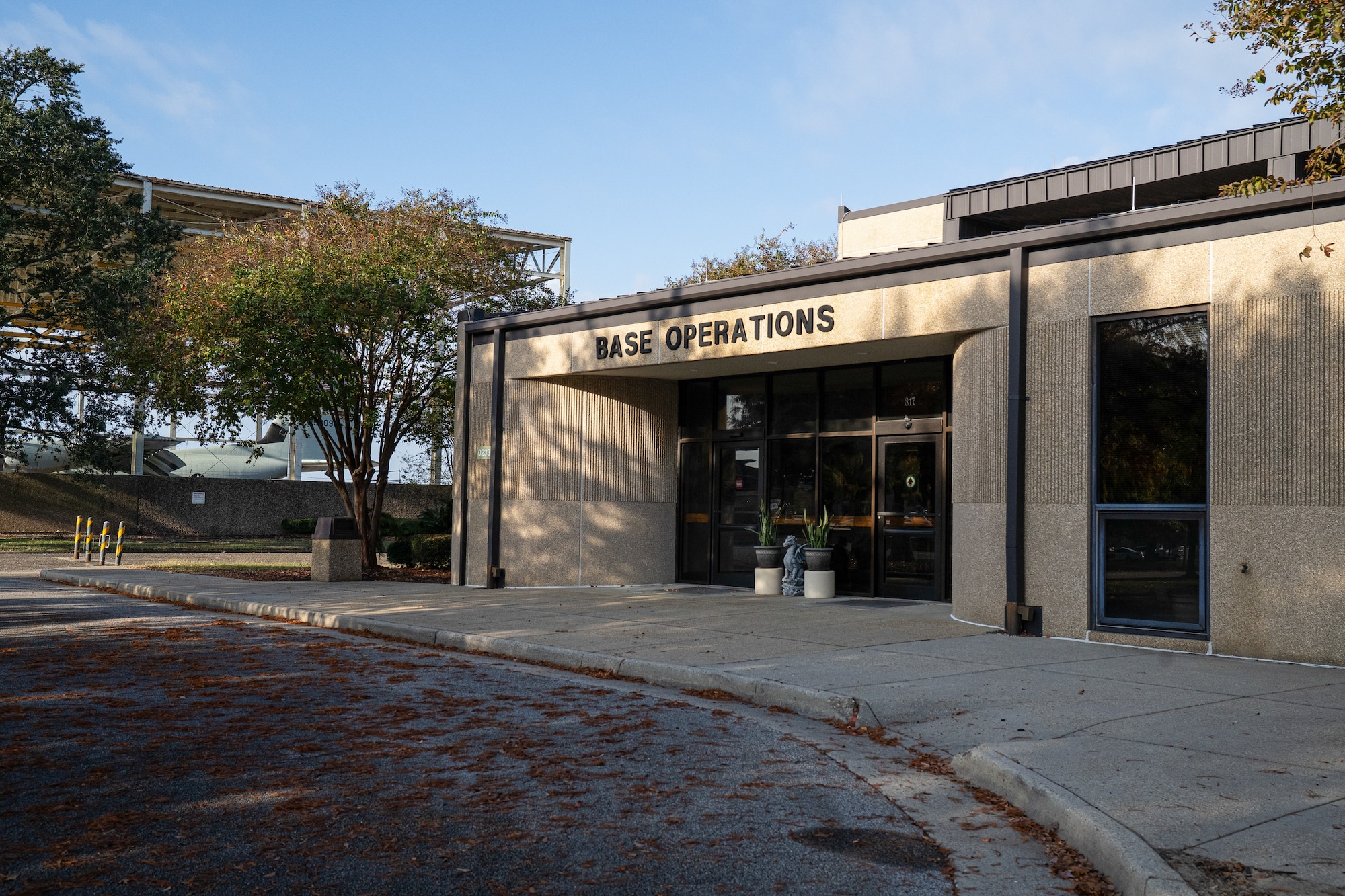 A tan building with trees around it.