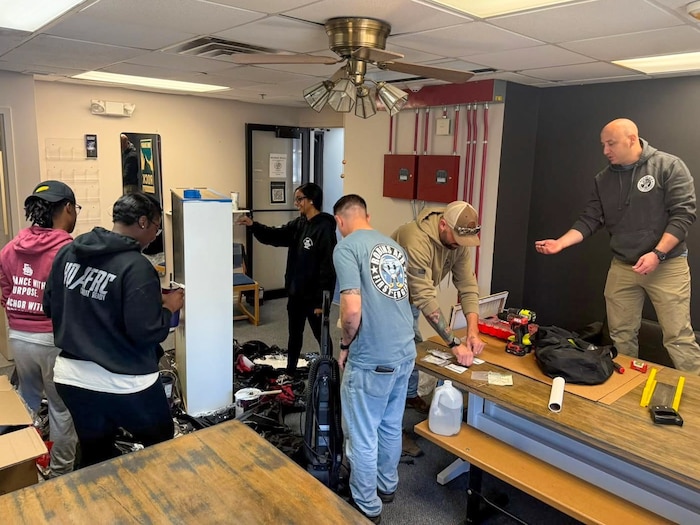 a group of first sergeants in civilian clothing work on various renovation projects in a room
