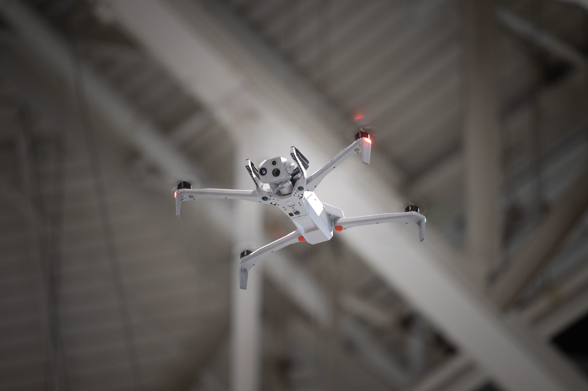 A small Unmanned Aircraft System (sUAS) flies in a hangar at McConnell Air Force Base, Kansas, Dec. 10, 2025. The sUAS is used to enhance installation safety, security, and operational awareness across the base. (U.S. Air Force photo by Senior Airman Paula Arce)