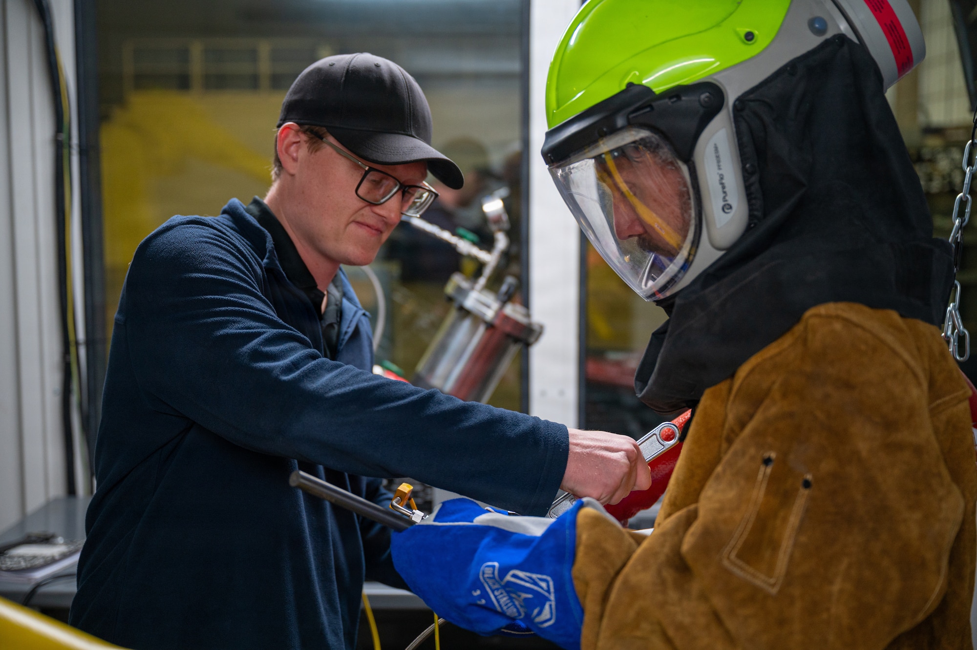 A cold spray engineer removes the spray nozzle from a robot arm.