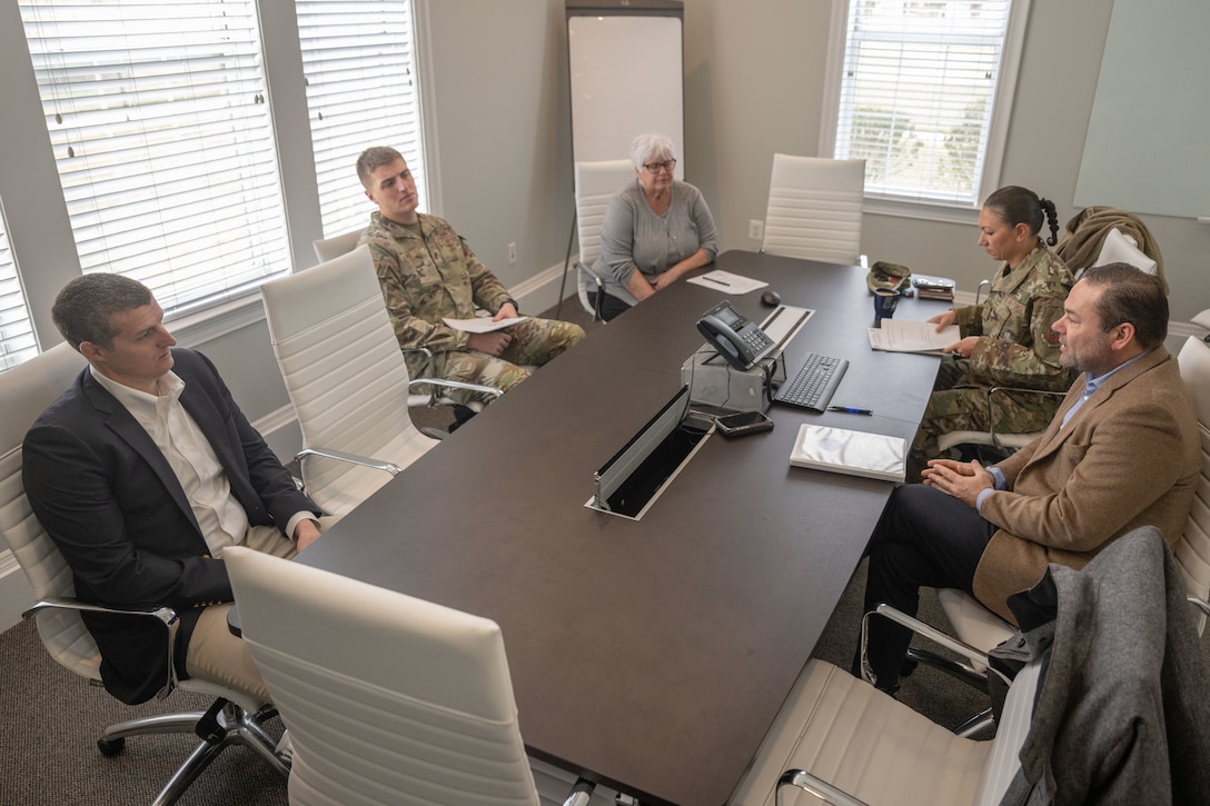 Group of people gather at a table having a meeting.
