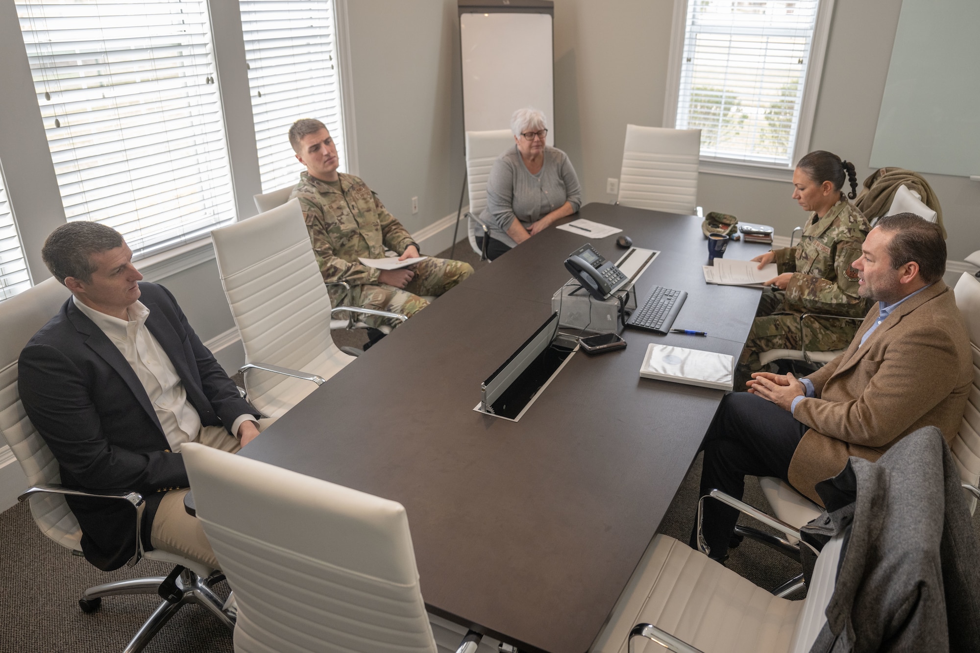 Group of people gather at a table having a meeting.