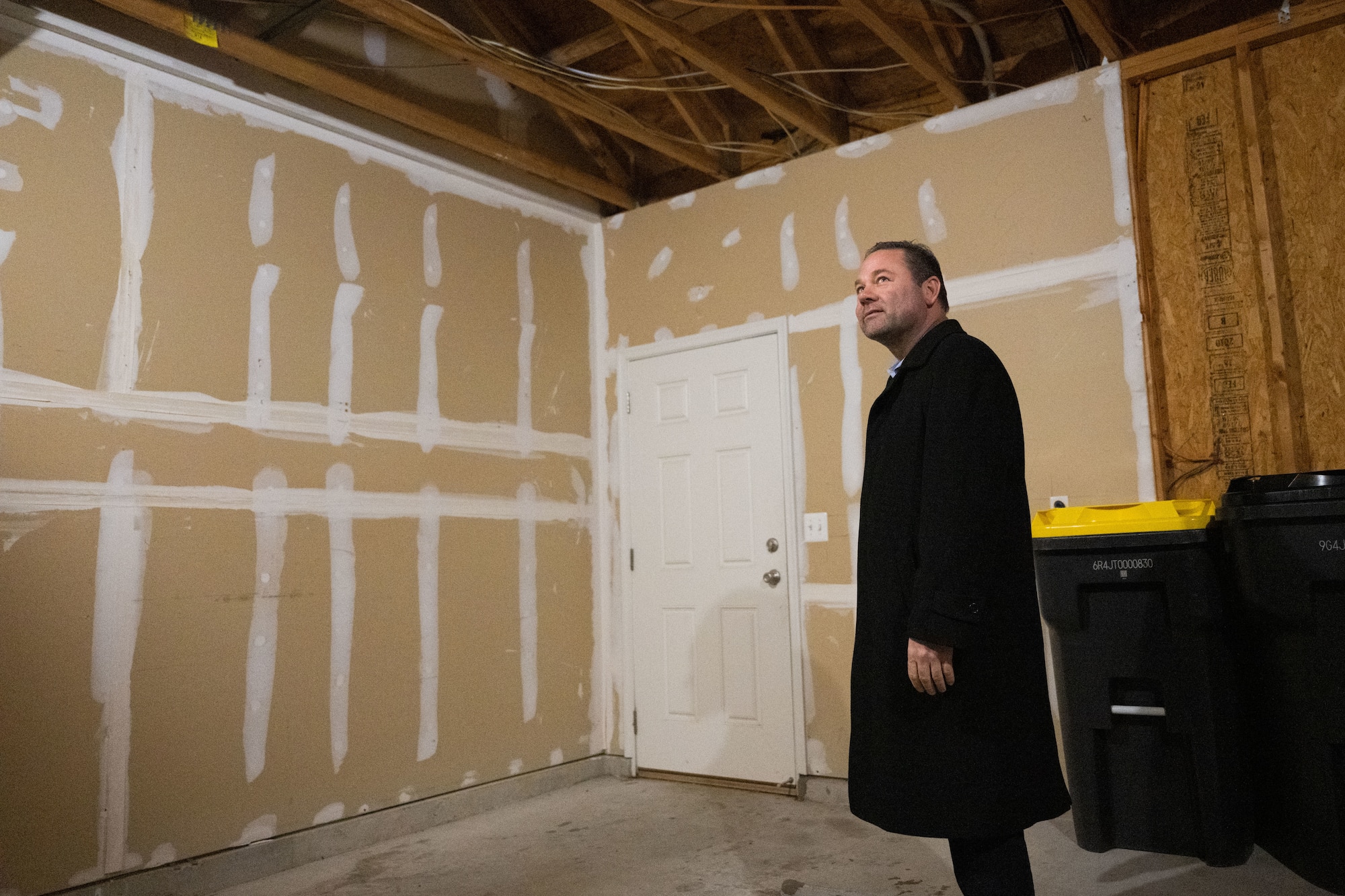 Man stands in empty garage under construction.