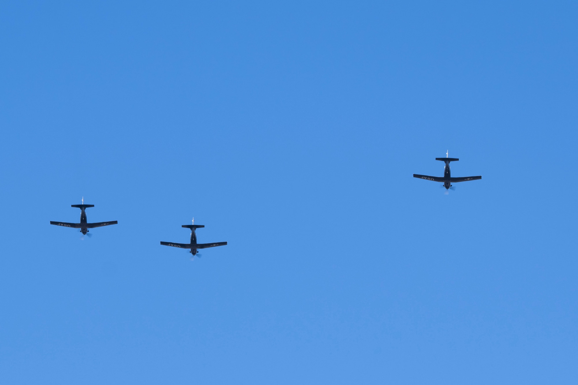 Three planes fly against a blue sky.