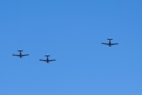 Three planes fly against a blue sky.