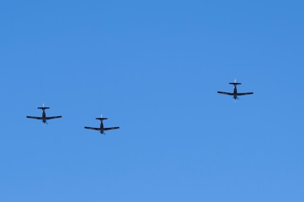 Three planes fly against a blue sky.