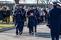 Honor Guardsmen carry an urn as the family observes.