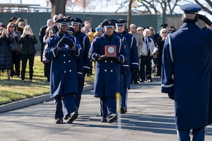 Honor Guardsmen carry an urn as the family observes.