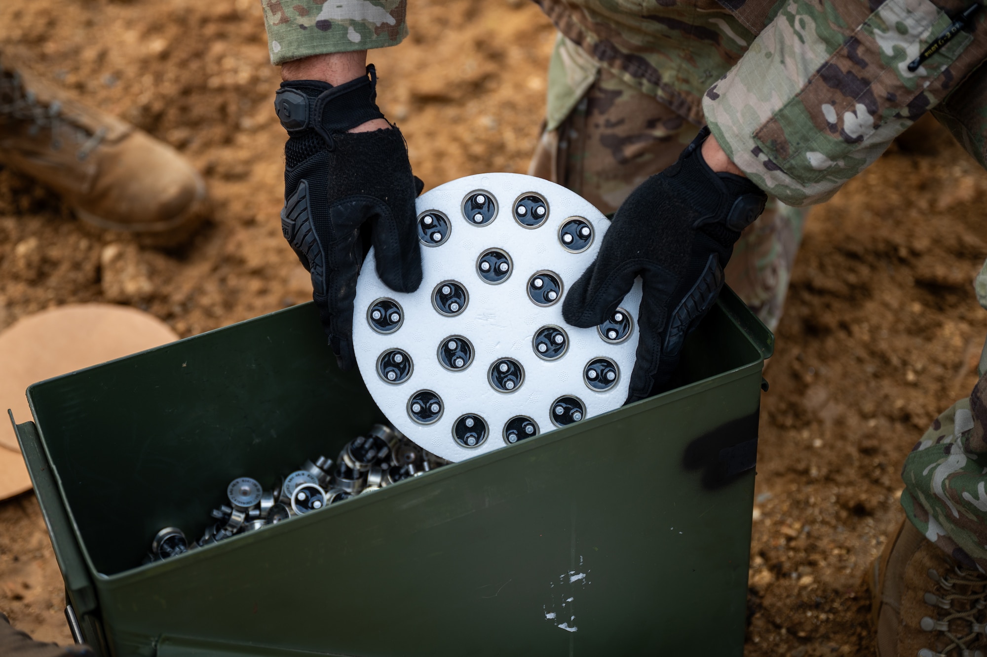 A U.S. Air Force Airman from the 18th Munitions Squadron prepares impulse cartridges used for flares during a scheduled disposal operation at Kadena Air Base, Japan, Dec. 18, 2025. The controlled detonation required close coordination with medical personnel and civil engineers to ensure mission safety and effectiveness. (U.S. Air Force photo by Airman 1st Class Francisco Huerta)