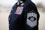 The rank insignia of a U.S. Space Force chief master sergeant is displayed on the sleeve of the new service dress uniform before a graduation ceremony at Joint Base San Antonio-Lackland, Texas, Dec. 18, 2025. The ceremony marked the first time the uniform was worn at a Department of the Air Force Basic Military Training graduation, highlighting the Space Force’s growing identity and presence within the joint enlisted training pipeline. (U.S. Air Force photo by Jonathan R. Mallard)
