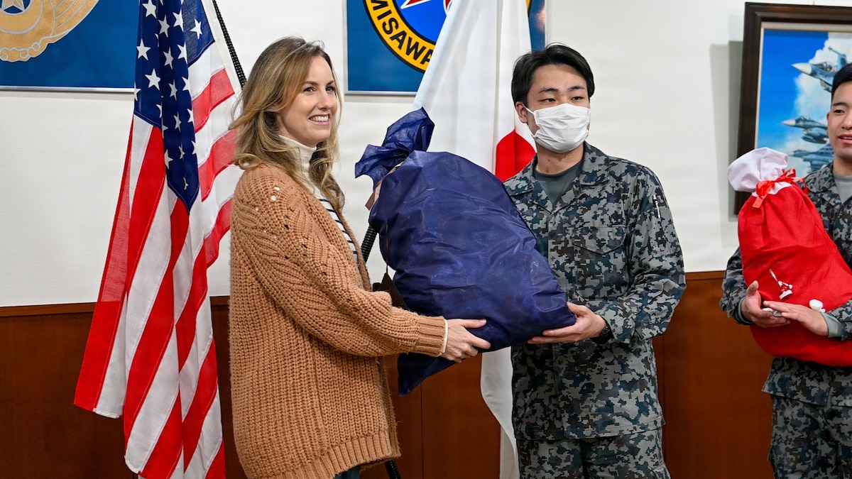 A Misawa Cookie Caper volunteer receives a gift bag from a Japan Air Self-Defense Force (JASDF) Airman assigned to the 3rd Air Wing at Misawa Air Base, Japan, Dec. 15, 2025. The exchange highlighted an ongoing partnership between Misawa volunteers and JASDF Airmen, showing how community-driven connections reinforce trust and teamwork throughout Misawa. (U.S. Air Force photo by Airman 1st Class Hannah Bench)