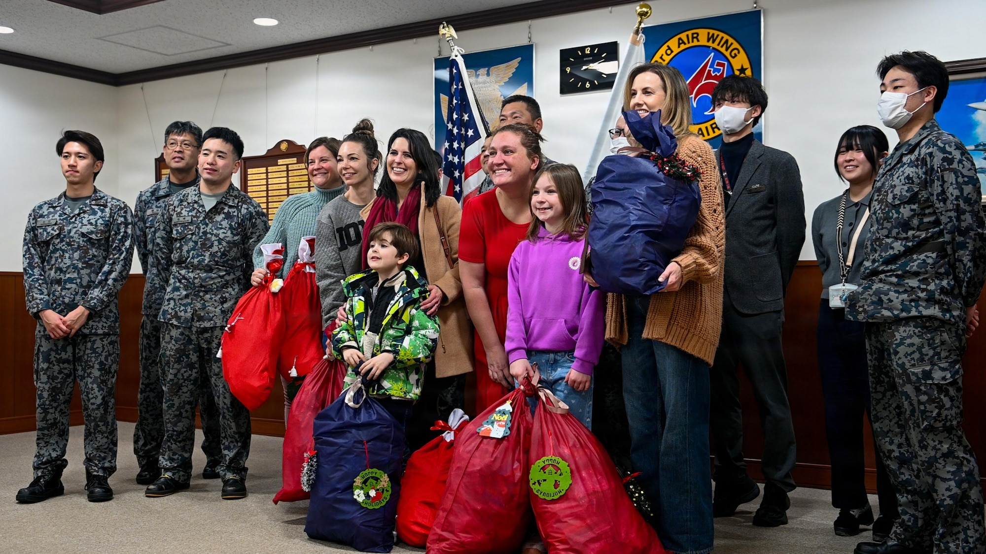 Misawa Cookie Caper volunteers pose for photos with Japan Air Self-Defense Force (JASDF) Airmen assigned to the 3rd Air Wing at Misawa Air Base, Japan, Dec. 15, 2025. Following a week earlier cookie delivery, JASDF Airmen presented thank-you gift bags to Misawa Cookie Caper volunteers, demonstrating how community engagement supports cohesion across Misawa. (U.S. Air Force photo by Airman 1st Class Hannah Bench)