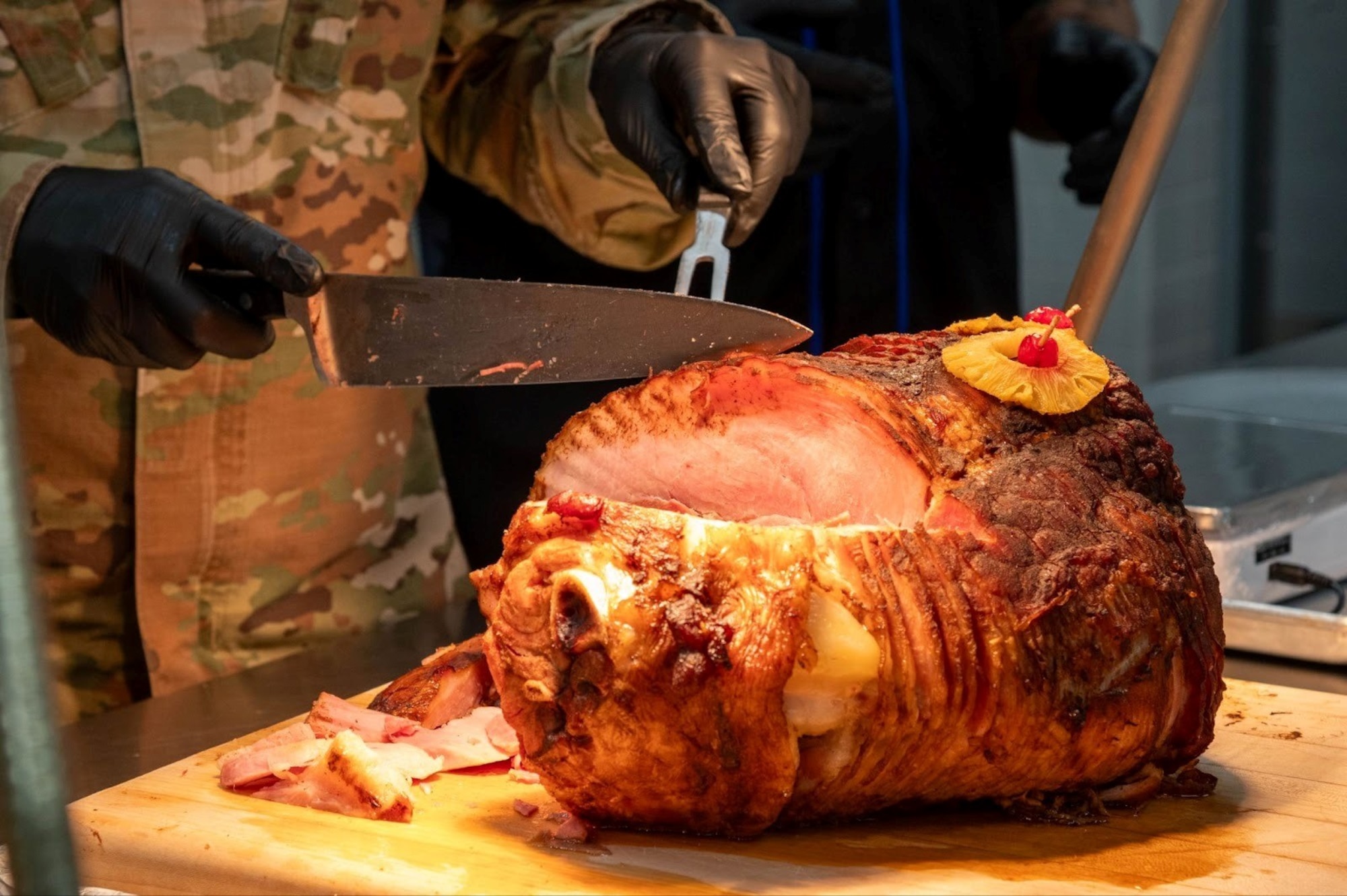 A volunteer cuts a piece of baked ham during the 2025 Grissom Dining Facility Christmas Lunch at Misawa Air Base, Japan, Dec. 25, 2025.