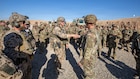 Command Sgt. Maj. Jason Frazee, command sergeant major of 6-17 Cavalry Squadron, 4th Combat Aviation Brigade, 4th Infantry Division, presents a coin and shakes hands with a German Soldier at the conclusion of the Schützenschnur qualification at Beneswala Range on Oct. 31, 2025. The recognition highlighted excellence in multinational marksmanship and reinforced professional bonds between partnered forces. (U.S. Army photo by Spc. Doniel Kennedy.)