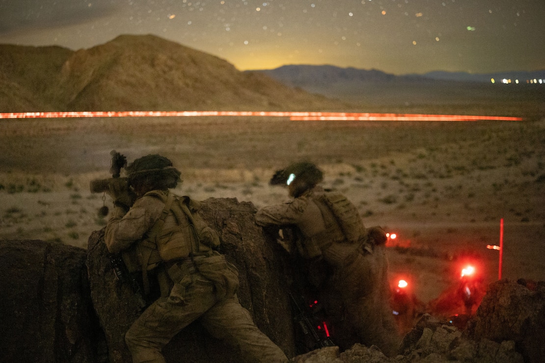U.S. Marine Corps 1st Lt. Jack Gallagher, left, an infantry officer, and Staff Sgt. Jacob Bustamante, an infantry unit leader, both with 2nd Battalion, 4th Marine Regiment, 1st Marine Division, coordinate suppressive fire during a night live-fire range during Service Level Training Exercise at Marine Corps Air-Ground Combat Center, Twentynine Palms, California, Dec. 17, 2025. SLTE is designed to be a challenging, realistic training environment that produces combat-ready forces capable of operating as an integrated Marine Air Ground Task Force across all domains of military operations. (U.S. Marine Corps photo by Cpl. Christian Cutter)