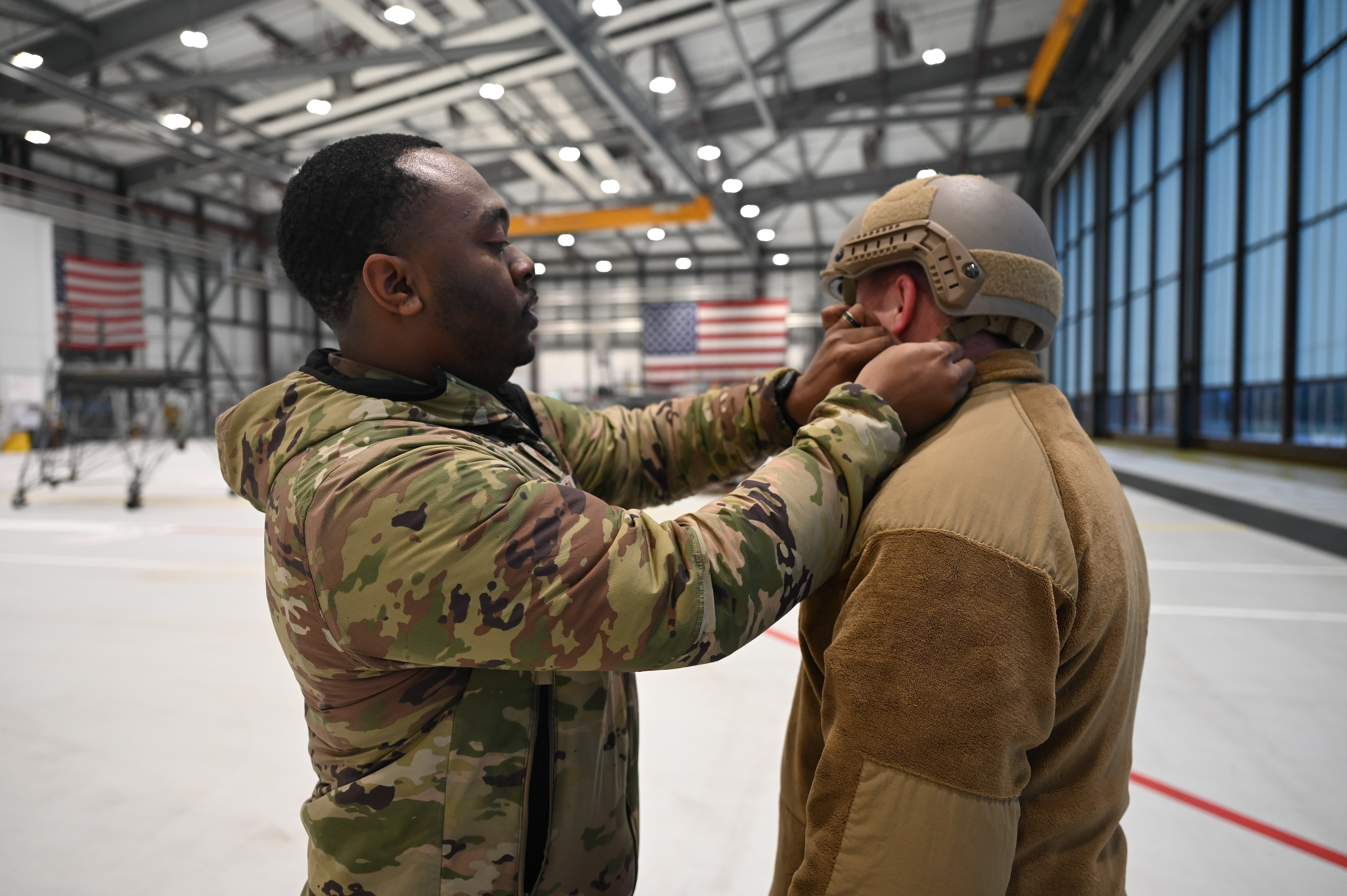 U.S. Air Force Tech. Sgt. Ezekiel Burke, 435th Air Ground Operations Wing Safety occupational safety manager, performs a safety check for Capt. Corey McGlynn, 435th AGOW executive officer, before members of the wing conduct static line jumps, at Ramstein Air Base, Germany. Burke is one half of the 435 AGOW Safety Office that was awarded 2025 United States Air Forces in Europe-United States Air Forces Africa Chief of Safety Outstanding Achievement Award Category IV, an award recognizing the most effective safety program. (U.S. Air Force photo by Capt. Amber R. Kelly-Herard)