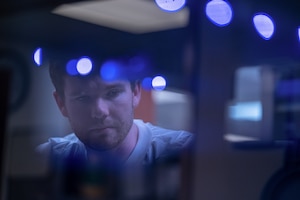 A man, from the neck up, looking into a machine.